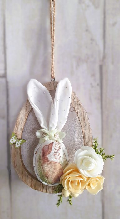 Poupée de Pâques avec des oreilles de lapin et des fleurs jaunes.
