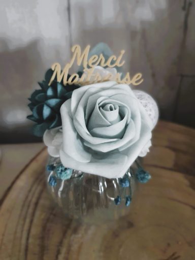 Arrangement floral avec une rose bleue et une inscription en bois "Merci Maman."
