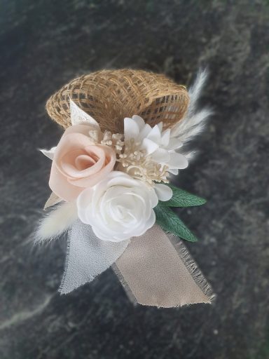 Fleur blanche et rose avec des éléments en jute et ruban décoratif.