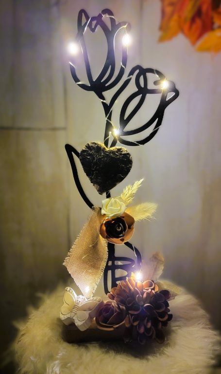 Sculpture en métal floral avec lumières et éléments décoratifs en automne.