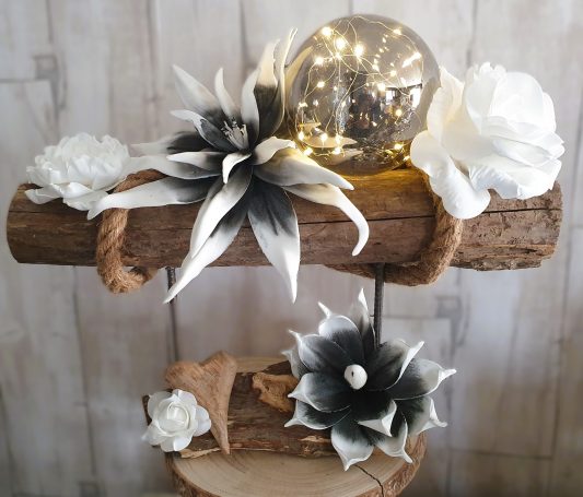 Décor floral en bois avec fleurs blanches et globe lumineux au centre.